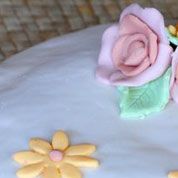 Particolare decorativo, torta di rose: base bianca con crema pasticcera, copertura e decorazione con pasta di zucchero.