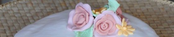 Particolare decorativo, torta di rose: base bianca con crema pasticcera, copertura e decorazione con pasta di zucchero.